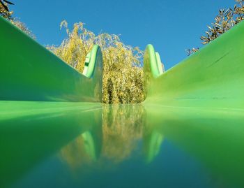 Surface level of slide against blue sky