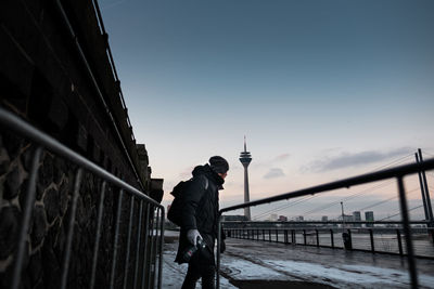 Man standing on snow covered city against clear sky