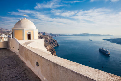 The aegean sea and the catholic church of st. stylianos in the city of fira in santorini island