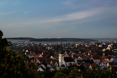 High angle view of townscape by sea against sky