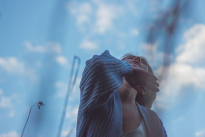 Portrait of woman looking at camera against sky