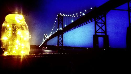 Low angle view of illuminated bridge against sky at night