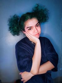 Portrait of beautiful woman against wall