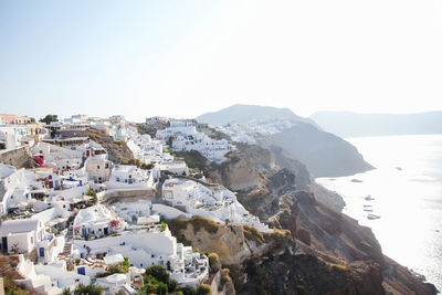 Residential district on mountain by sea against clear sky during foggy weather