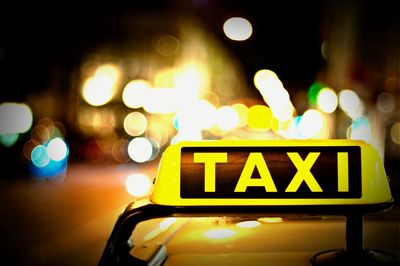 Close-up of illuminated taxi sign on taxi in city