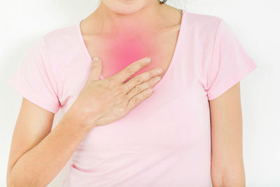 Midsection of woman touching pink flower