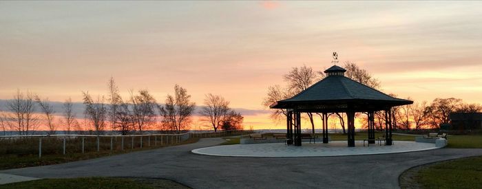 Gazebo in park against sky during sunset