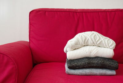 Closeup shot of warm sweaters on red sofa in living room