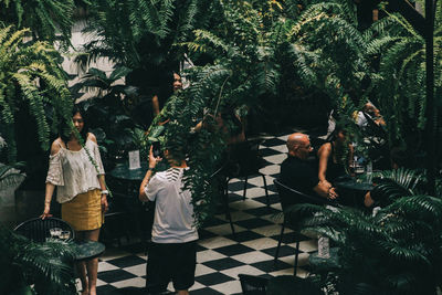 Rear view of people standing by plants