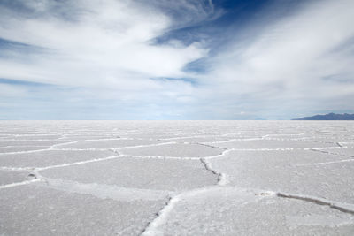 Surface level of salar de uyuni against cloudy sky