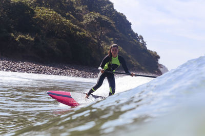 Female sup surfer on a wave