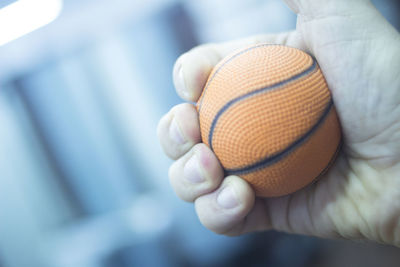 Cropped hand of person holding ball at home