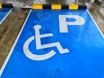 High angle view of parking and wheelchair access sign on road