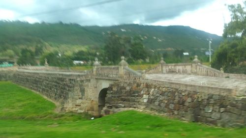 Arch bridge against cloudy sky