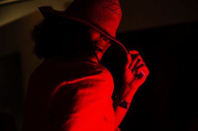 Rear view of man wearing hat standing at night