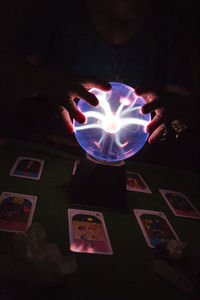 Midsection of woman holding illuminated ball at night