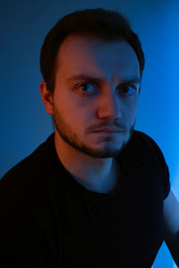 Portrait of young man against blue background