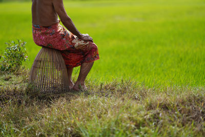 Low section of woman standing on field