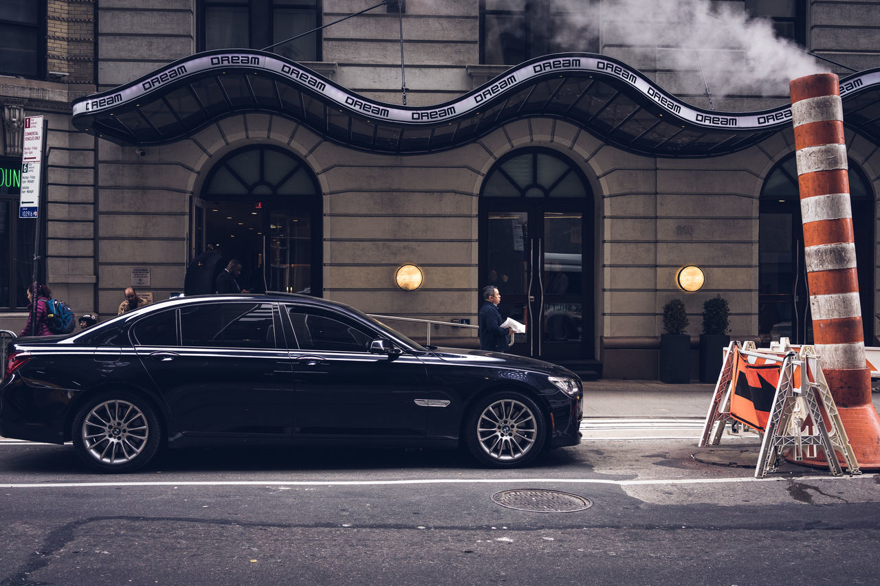 mode of transportation, transportation, car, motor vehicle, architecture, vehicle, building exterior, built structure, city, land vehicle, automobile, street, luxury vehicle, wheel, road, sign, day, no people, outdoors