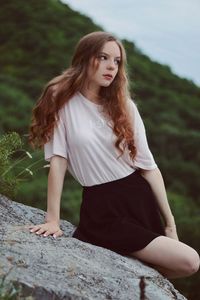 Portrait of beautiful young woman sitting outdoors