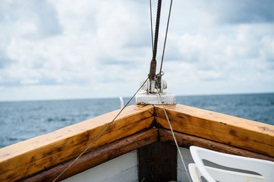 Fishing boat sailing on sea against sky