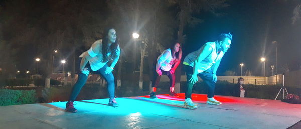 People by illuminated lights at night