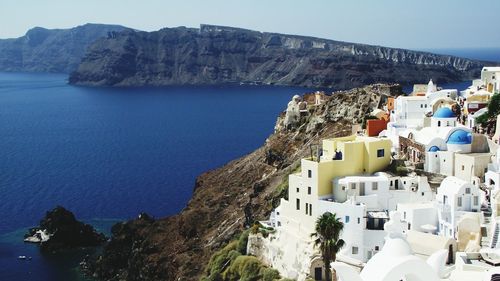 Town at santorini with rocky mountains at aegean sea