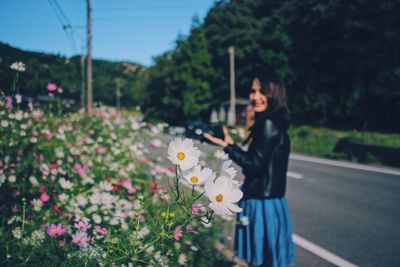 Woman standing by flowering plants