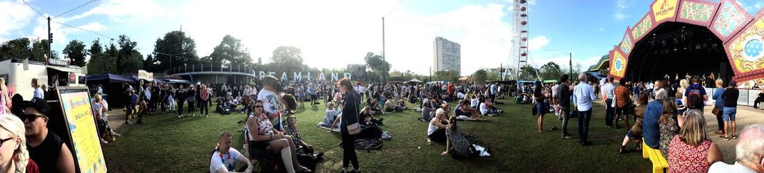 Panoramic shot of crowd on grass against sky