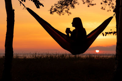 A european woman in a hammock on the sunset.  camping
