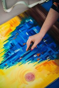 Cropped hand of female artist painting on canvas