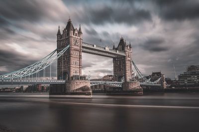 View of bridge over river against cloudy sky