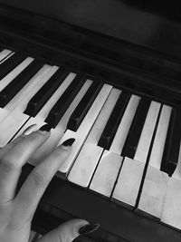 Close-up of hand playing piano