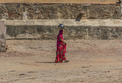 Side view of woman standing against wall