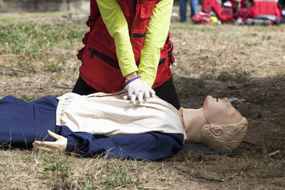 Midsection of paramedic performing cpr on mannequin