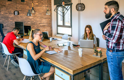 Angry female manager discussing with man for coming late to office