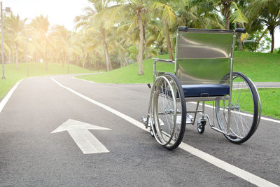 Empty wheelchair on road with arrow symbol