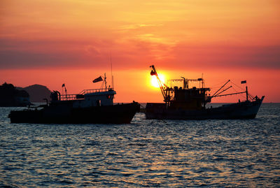 Silhouette ship in sea against sky during sunset