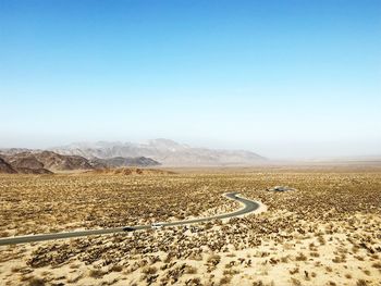 Scenic view of desert against clear blue sky