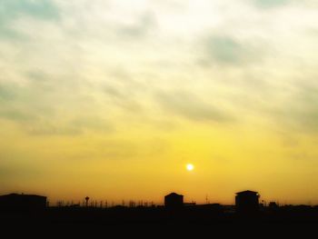 Silhouette cityscape against sky during sunset