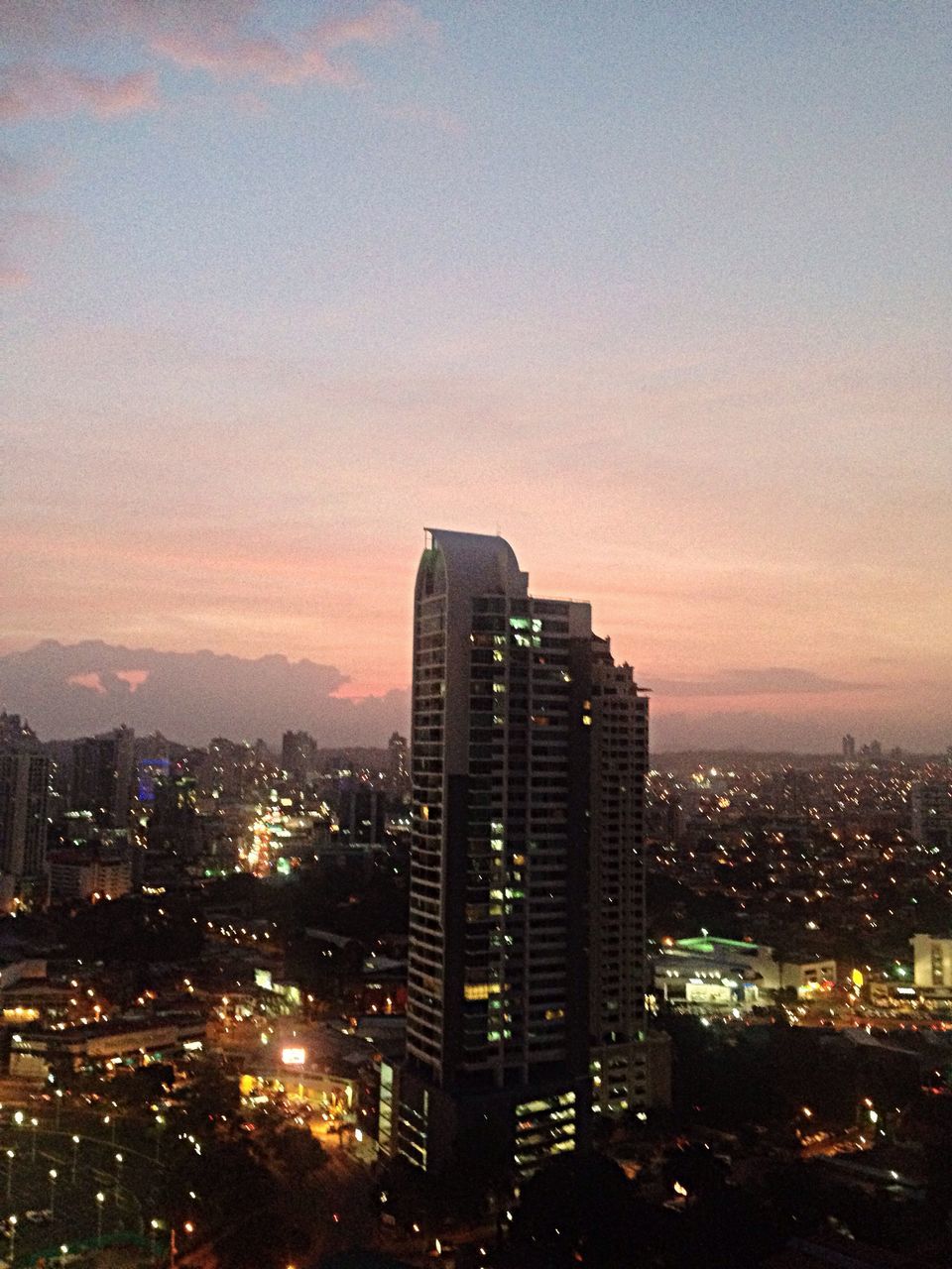 building exterior, city, architecture, cityscape, built structure, skyscraper, tower, modern, illuminated, tall - high, sky, office building, sunset, crowded, urban skyline, high angle view, city life, dusk, night, residential building