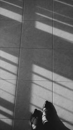 Low section of woman standing on tiled floor