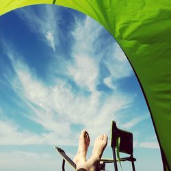 Low section of man lying down against sky
