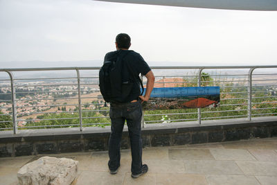 Rear view of man looking at sea against sky