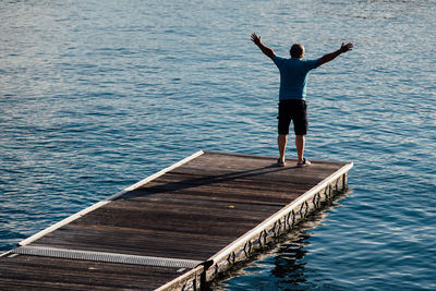 Full length of man standing on pier over lake