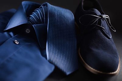 Close-up of shirt with necktie and shoe on table