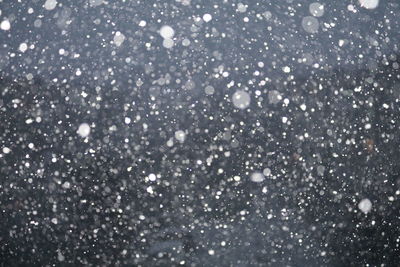 Snowing against sky at night