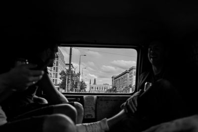 Man photographing through window in bus