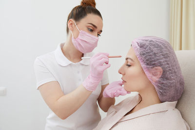 Female doctor examining patient at home