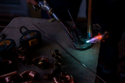 A worker welds copper pipes with a gas torch for central heating